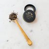 brass measuring scoop with loose leaf black tea