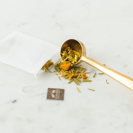 brass measuring scoop with loose leaf herbal tea